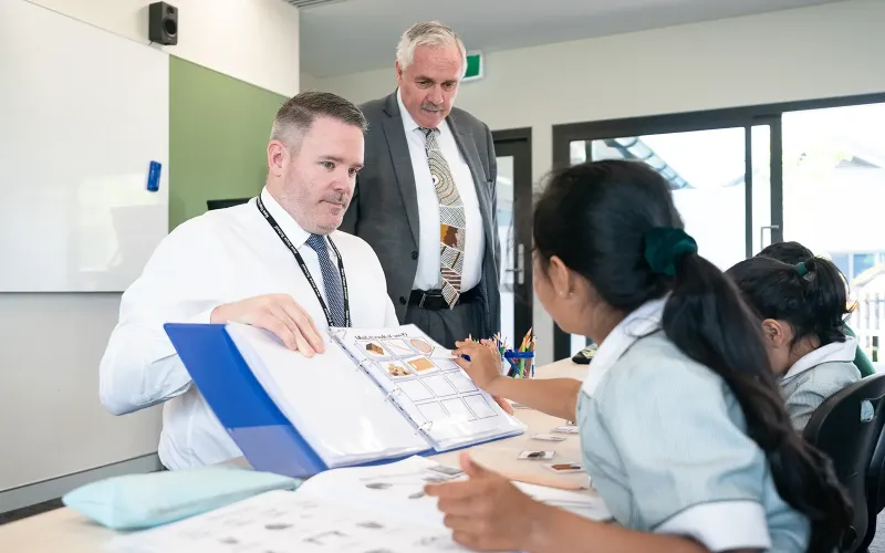 Junior school students and teacher working together at New Hope Christian School